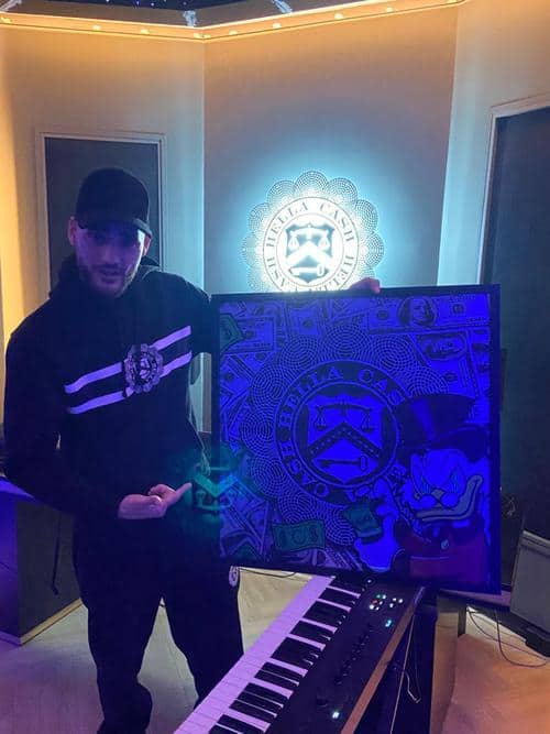 Josylvio-holding-DutchieArts-artwork-in-studio